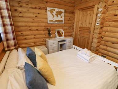 A bedroom with a bed with pillows and towels a dresser with a mirror and a map on the wall at Starwood in Felton