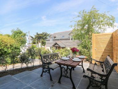 An outdoor patio with a table and chairs at Joe’s Barn in Mullion