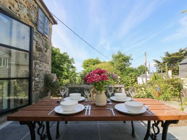 A dining area with a table set for meal at Joe’s Barn in Mullion