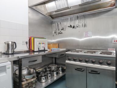 A kitchen with a stove pots utensils chopping boards and a kettle at Brimpts Barn Dartmeet near Princetown