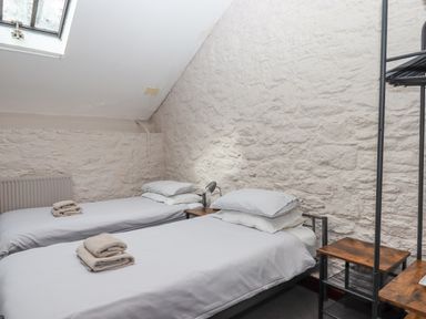 A bedroom with two single beds and towels on each bed at Brimpts Barn Dartmeet near Princetown