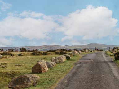 A paved road with large rocks along the side in a rural landscape at Brimpts Barn in Dartmeet near Princetown