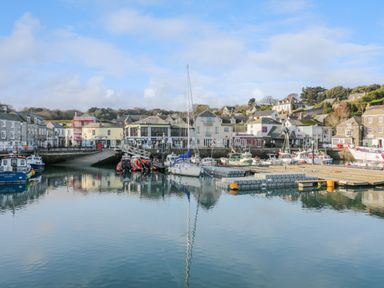 A harbor with boats docked and buildings in the background at Cornish Holiday at Atlantic Bays in St Merryn