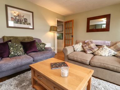 A living room with two sofas and a wooden coffee table at Lavender Cottage in Coniston