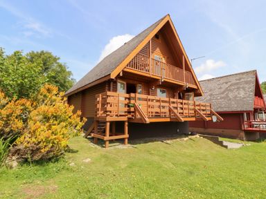 A wooden house with balconies and a garden at Thistle Dubh ("Doo") Sandyhills