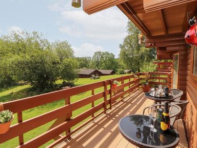 An outdoor balcony with a table and chairs at Thistle Dubh (