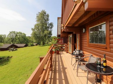 A balcony with a table and chairs at Thistle Dubh ('Doo') Sandyhills