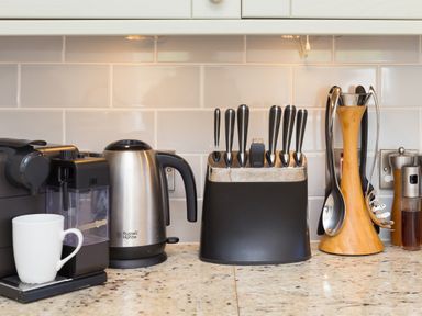 A kitchen countertop with a coffee machine, electric kettle, knife block, and kitchen utensils at Rebecca in Mullion Cove near Mullion