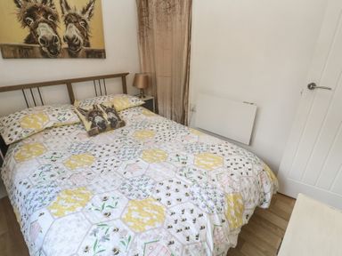 A bedroom with a bed and wall art at Tolroy Manor Holiday Park St Erth Praze near Hayle