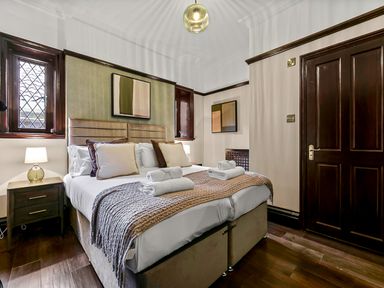 A bedroom with a double bed bedside tables and lamps at Tudor Grange in Bournemouth