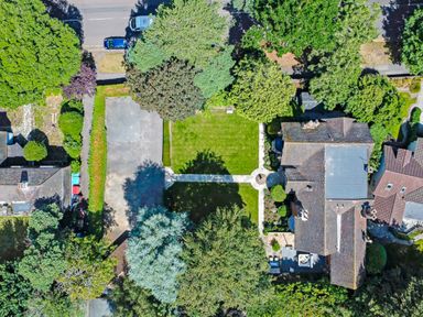An aerial view of a house with a garden driveway trees and neighboring houses at Tudor Grange in Bournemouth