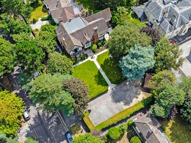 An aerial view of a house with a garden and driveway surrounded by trees at Tudor Grange in Bournemouth