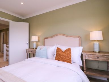 A bedroom with a bed with pillows and bedside tables with lamps at The Farmhouse in St Osyth
