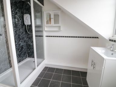 A bathroom with a shower enclosure a mirror cabinet and a sink unit at Tan Y Fron in Dyffryn Ardudwy