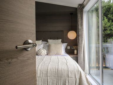 A bedroom with a bed and window at Lodge 6 St. Osyth