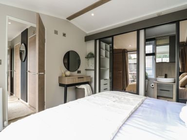 A bedroom with a bed and table at Lodge 6 in St. Osyth