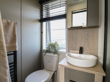 A bathroom with a toilet and sink at Lodge 6 St. Osyth