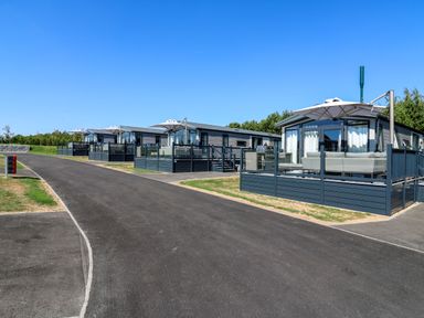 A row of cabins with decks along a road at Lakewood Plot 2 in St. Osyth
