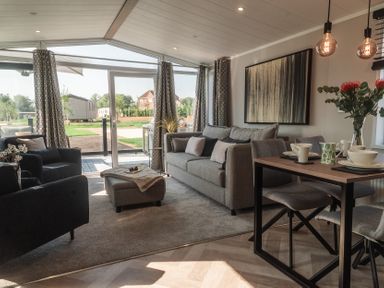 A living room with a sofa and dining table at Lakewood Plot 2 in St. Osyth