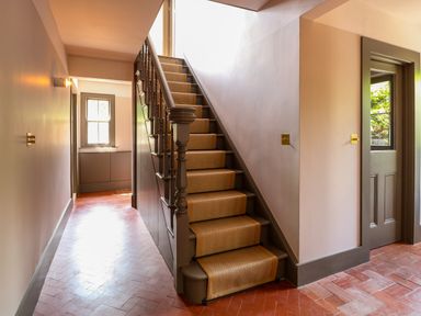 A hallway with stairs and a door beside it at Oak Cottage in Somerleyton