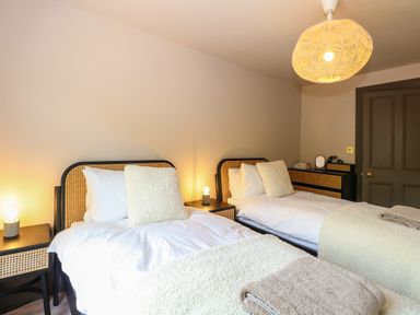 A bedroom with two single beds side by side with nightstands and lamps at Oak Cottage in Somerleyton