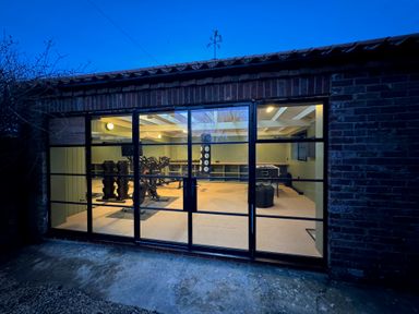 A gym with exercise equipment and weights at Oak Cottage in Somerleyton