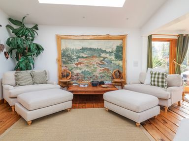A living room with seating and a wall tapestry at Burlodge in Swimbridge near Barnstaple