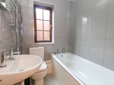 A bathroom with a sink toilet bathtub and a window at Coldharbour Farm Bungalow Annexe Coldharbour near Wareham