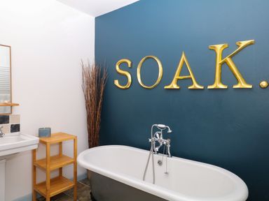 A bathroom featuring a bathtub and sink at Burrows in Venn Ottery near Sidmouth