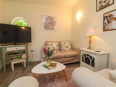 A living room with a sofa and television at Sunset Cottage in Swimbridge near Barnstaple