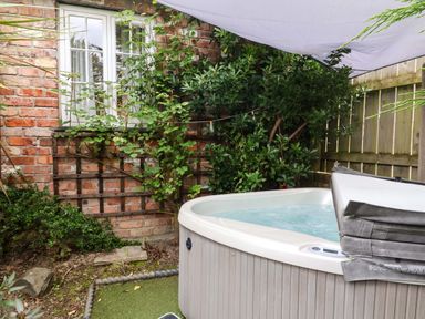 A hot tub in a garden at Sunset Cottage in Swimbridge near Barnstaple