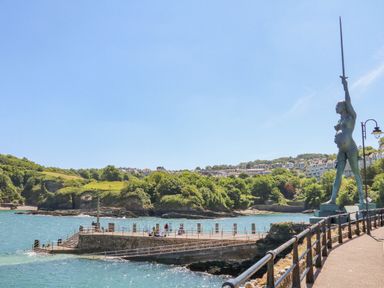 A seaside pier with people fishing and a large statue holding a sword at Burr 1 Shepherds Hut in Barnstaple