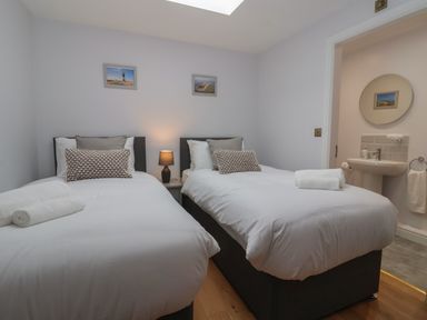A bedroom with two single beds and a lamp between at Waverley Cottage in Kilnsea near Easington Hull