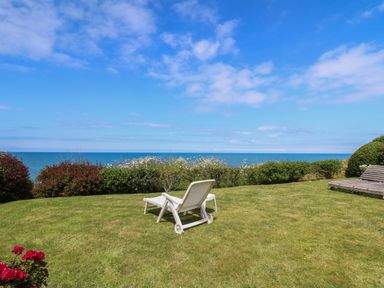 A garden with two lounge chairs overlooking the sea at Pen y Graig in Aberporth