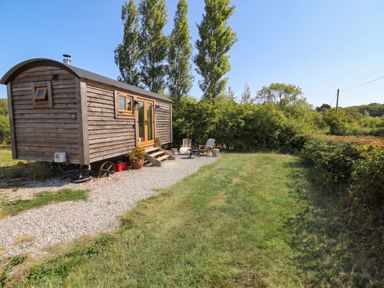 A tiny house with a gravel path and chairs in an outdoor space at Cariad Mawr Gwaenysgor near Prestatyn