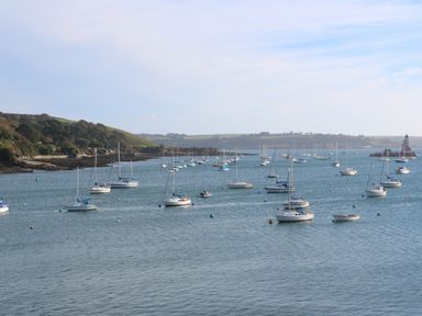 A bay with many sailboats anchored and hills in the background at Cuckoo's Rest in Penryn