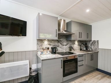 A kitchen with cabinets and appliances at Squirrels Lodge in South Molton