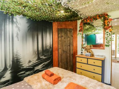 A bedroom with a bed and towels at Squirrels Lodge in South Molton