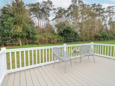 A deck with two chairs and a small table with a flower and coffee at No 3 Foxburrow Hang in Belton