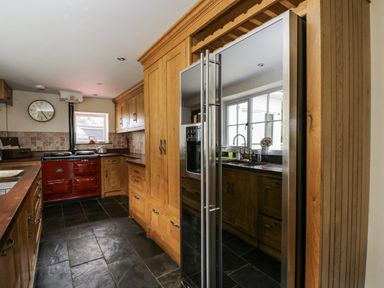 A kitchen with an oven and refrigerator at Woods Cottage in Kingcoed near Raglan