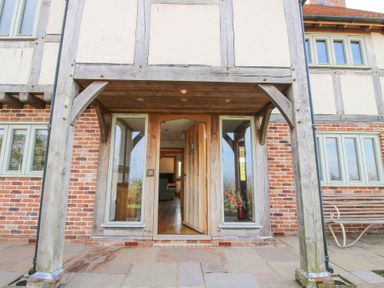 The entrance of a brick and timber house with a wooden door and windows at Cuckoo Pen Cottage Eastham near Tenbury Wells