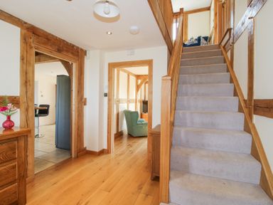 A hallway with wooden floors stairs and doorways leading to other rooms at Cuckoo Pen Cottage Eastham near Tenbury Wells