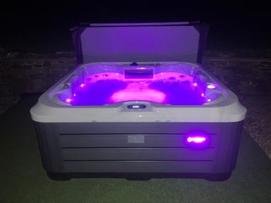 A hot tub with purple lights on a grass surface at Cuckoo Pen Cottage in Eastham near Tenbury Wells