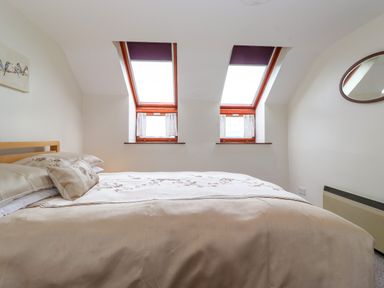 A bedroom with a bed under two skylight windows at Addyfield Farmhouse Cartmel Fell near Bowland Bridge