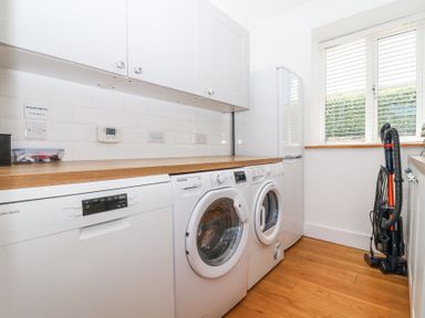 A laundry room with washing machine dryer dishwasher refrigerator and vacuum cleaner at Old Orchard Barn St Mellion near St Dominick