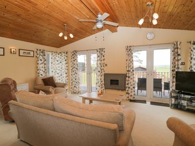 A living room with sofas a coffee table a fireplace and a television at Lodge 16 Whitsand Bay near Millbrook