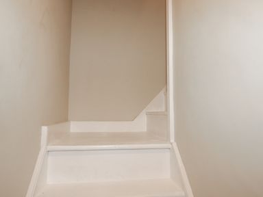 A small white staircase with beige walls at Carew House Cottage in St Day