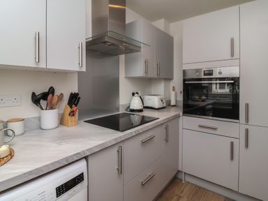 A kitchen with cabinets and appliances at Seashell Sands in Appledore