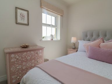 A bedroom with a bed and dresser at Seashell Sands in Appledore