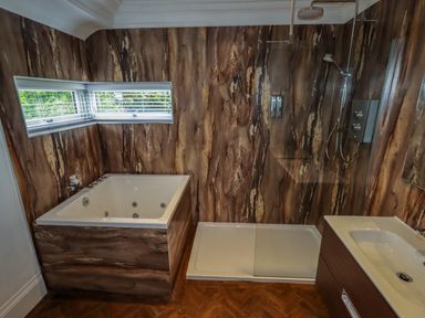 A bathroom with a bathtub shower enclosure and sink at The Manor House Skerry Vore Bryn Pydew near Llandudno Junction